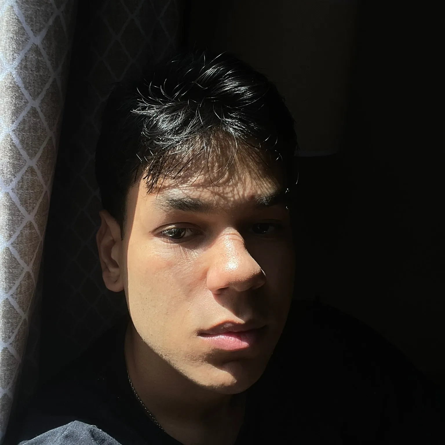 Retrato de Marcello Valente sob luz de janela, o rosto metade na sombra